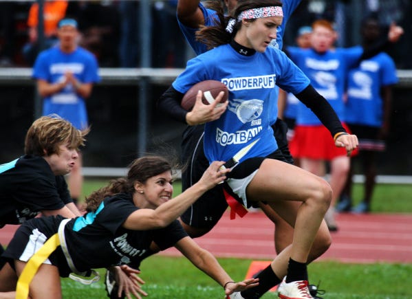 Groveport Madison teachers Brandy Grieves, far left, and Amy Bisesi try to tackle senior Shelbie Prince, 17. No such luck: Prince scored a touchdown during the Powder Puff football game yesterday. The senior girls won the scrimmage, part of homecoming week activities.