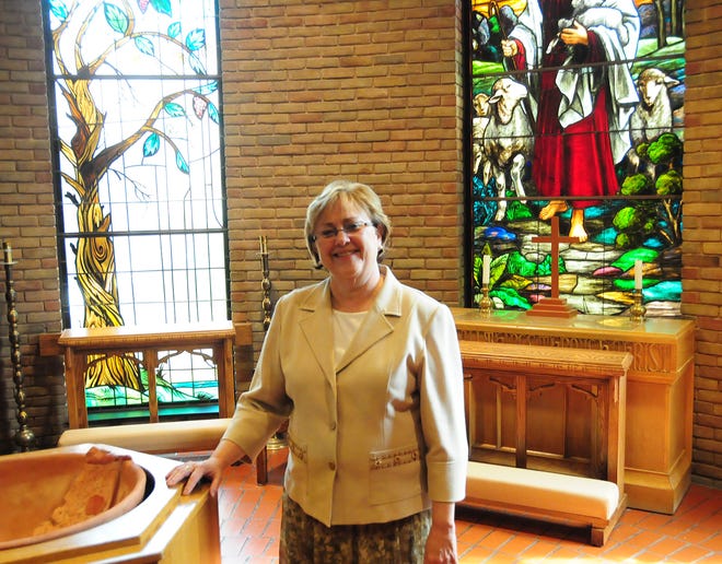The Rev. J. Lynn Pier-Fitzgerald of the First United Methodist Church of Holland stands in front of a stained glass window that has been a part of the church building since about 1920.
