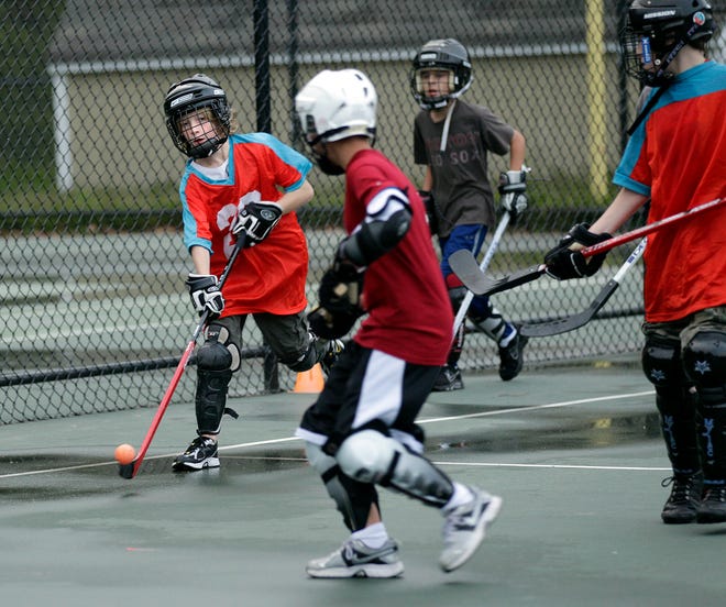 Jake Derocher, 12, of Upton, dribbles up the court during a street hockey game behind Memorial Elementary School in Upton.