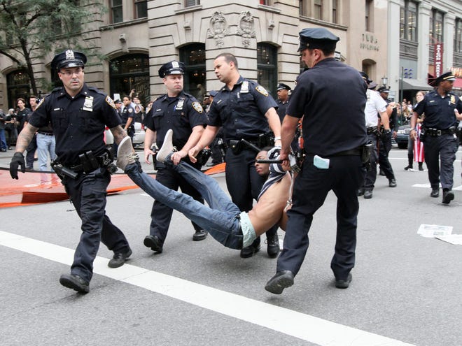 Police carry away a participant in a march organized by Occupy Wall Street in New York on Saturday Sept. 24, 2011. Marchers represented various political and economic causes. (AP Photo/Tina Fineberg)