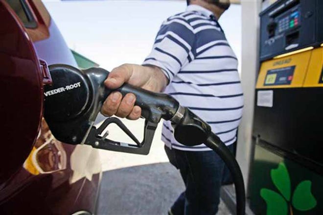 In this Feb. 24, 2011 file photo, Juan Zuniga gasses up an SUV in Dallas. For the first time in months, retail gasoline prices have fallen below $3 a gallon in places, including parts of Michigan, Missouri and Texas. And the relief is likely to spread thanks to a sharp decline in crude-oil prices.