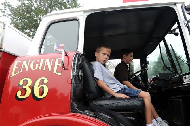 Nicholas Curro, 8, left, and his friend Michael Brown, 8, take a ride in the fire truck. East Bridgewater 8-year-older Nicholas Curro won a Matthew Pollini award at a silent auction. He got ride to the Central Elementary School, in a fire trick, on September 27, 2011. A Fire Truck for all Occasions of Pembroke, owner is Mike Watts, a Weymouth firefighter. Pfc. Matthew Pollini, was a Rockland resident killed in Iraq.