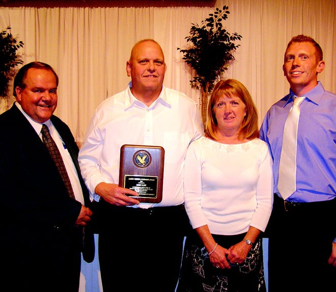 Barry Kline received a plaque for his community service from Joel Fridgen, left, executive director of the Greencastle-Antrim Chamber of Commerce. Kline, co-owner of Kline's Grocery in Shady Grove, was accompanied by his wife Bonnie and son Kevin at the awards banquet.