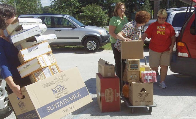 Hasting librarians, from left, Michelle Kiley, Ellen Walden and Rita Foust unload boxes of non-perishable goods from Malea Guiriba's van outside of the library on Wednesday, September 28, 2011. BY MARCIA LANE, marcia.lane@staugustine.com