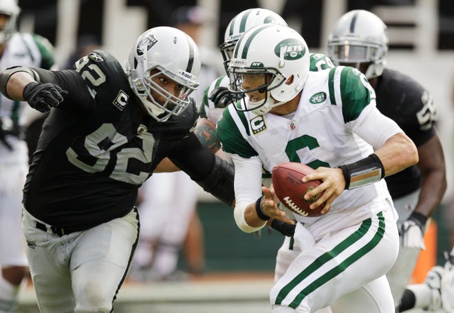 New York Jets quarterback Mark Sanchez (6) is pursued by Oakland Raiders defensive tackle Richard Seymour (92) in action against the Oakland Raiders in an NFL football game in Oakland, Calif. Sunday, Sept. 25, 2011. (AP Photo/Ben Margot)