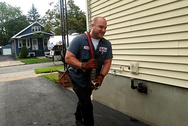 Jamie Mathias oil delivery worker with Fred S. Collis & Sons Heating and Cooling pulls a hose used to put oil in a home Friday Sept. 23, 2011.