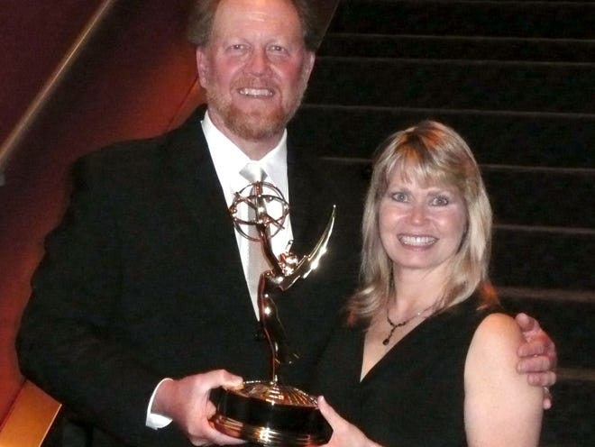 Mark Emery and his wife Mary pose with an Emmy statuette after winning he won an Emmy on Monday for his outdoor cinematography as part of National Geographic's series "Great Migrations." (Courtesy of Mark Emery)