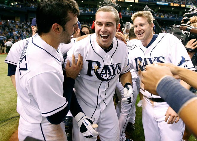 Tampa Bay Rays, from left, Sean Rodriguez, Evan Longoria, and Elliot Johnson celebrate clinching the AL Wild Card with an 8-7 win over the New York Yankees during a baseball game Thursday, Sept. 29, 2011, in St. Petersburg, Fla. (AP Photo/Chris O'Meara)