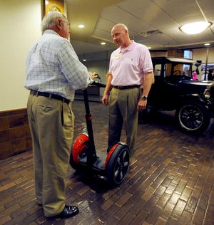 Eric Westermann, right, talks with Chuck Short about his Segway model I-180 before he takes it for a ride during McCormick Co. and Neely, Craig & Walton LLP celebrations in the Virgil Patterson Auditorium of Happy State Bank.