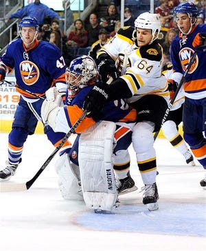 Boston Bruins' Lane MacDermid, center left, fights for position with New York Islanders' Evgeni Nabokov (64) during the second period of a preseason NHL hockey game in Bridgeport, Conn., on Saturday, Oct. 1, 2011. Looking on are Islanders Andrew MacDonald, left, and Travis Hamonic. (AP Photo/Fred Beckham)