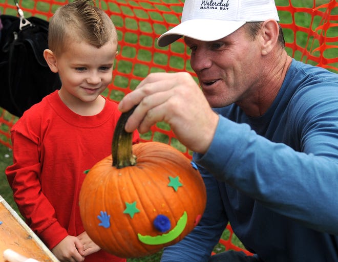 Patrick Mchugh and Patrick Mchugh, Jr., 4, of Bridgewater, look at the pumpkin they decorated together at the NRT Sheep Pasture's 38th Annual Harvest Fair in Easton on Sunday, October 2, 2011.