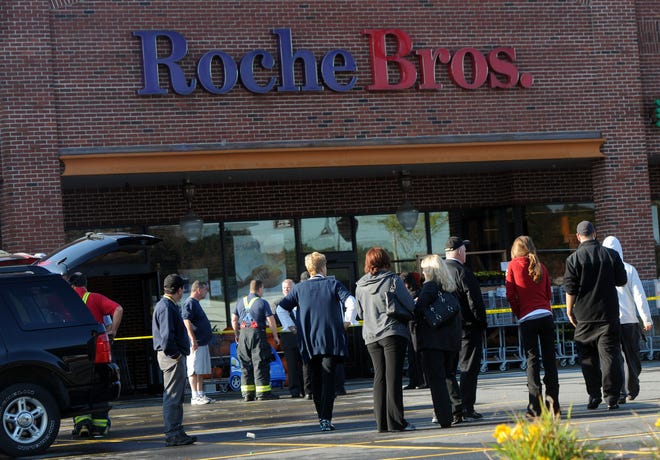 Employees of the Roche Bros. supermarket on West Central Street in Natick wait outside after Friday morning's kitchen grease fire. The store reopened Saturday morning.