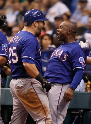 The Rangers' Esteban German, right, congratulates Mike Napoli after Napoli hit a two-run home run in the seventh inning on Monday.