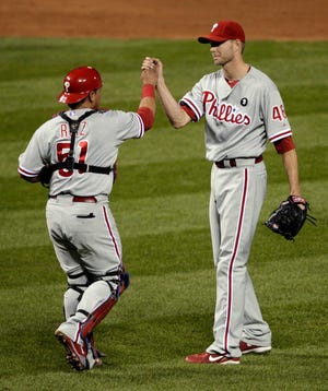 Philadelphia Phillies relief pitcher Ryan Madson, right, and catcher Carlos Ruiz celebrate after the Phillies' 3-2 victory over the St. Louis Cardinals in Game 3 of baseball's National League division series Tuesday, Oct. 4, 2011, in St. Louis. (AP Photo/Tom Gannam)