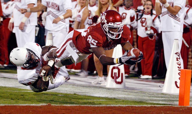Oklahoma wide receiver Ryan Broyles, right, dives into the end zone with a touchdown as Ball State defender Brian Jones, left, attempts the tackle in the second quarter of an NCAA college football game, Saturday, Oct. 1, 2011, in Norman, Okla (AP Photo/Sue Ogrocki)