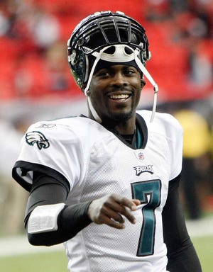FILE - In this Dec. 6, 2009, file photo, Philadelphia Eagles quarterback Michael Vick smiles as he prepares for an NFL football game against the Atlanta Falcons in Atlanta. Vick won the Ed Block Courage Award, voted on by his teammates on the Philadelphia Eagles, after the once-disgraced star quarterback returned to the league after spending 18 months in a federal prison for his role in a dogfighting ring. (AP Photo/Dave Martin, File)