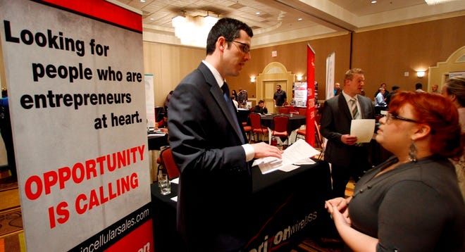 Blake Andrews with Verizon, left, visits with prospective employees during a job fair in San Antonio on Oct. 4. The United States added 103,000 jobs in September, a burst of hiring that followed a sluggish summer for the economy. The figure at least temporarily calms fears of a new recession that have hung over Wall Street and the nation for weeks. (The Associated Press)