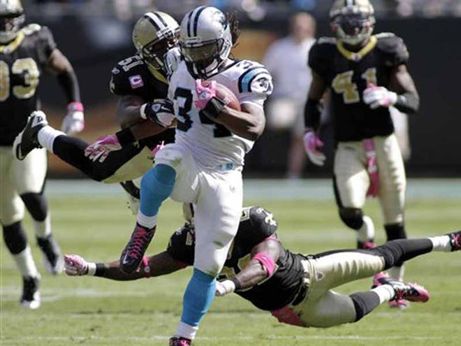 Carolina Panthers' DeAngelo Williams (34) runs past New Orleans Saints' Jonathan Vilma (51) and Tracy Porter (22) for a touchdown during the second quarter of an NFL football game in Charlotte, N.C., Sunday, Oct. 9, 2011. (AP Photo/Rick Havner)