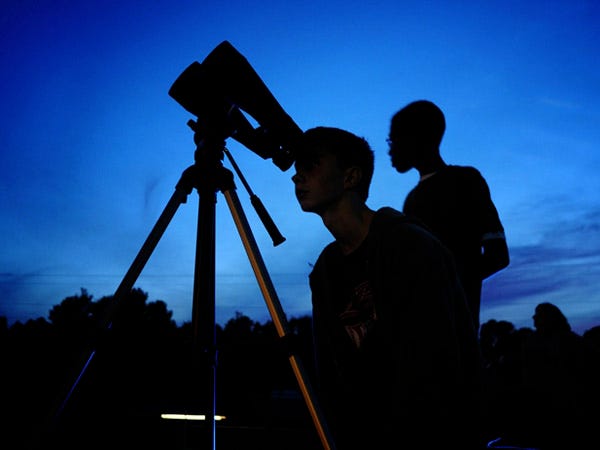 Burgaw Middle School student Charles Frati and other students peer through high powered binoculars for a special chance to glance at the Moon and other celestial bodies through a special grant the school received for International Observe the Moon Day.