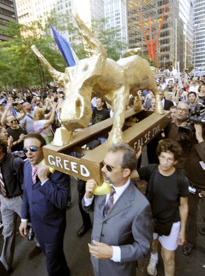 Occupy Wall Street demonstrators carry a "false idol" to New York's Zuccotti Park to protest economic inequities.