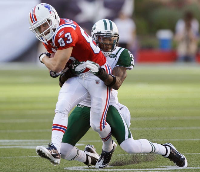 New England Patriots wide receiver Wes Welker (83) tries to elude New York Jets cornerback Antonio Cromartie (31) during the first quarter of an NFL football game in Foxborough, Mass., Sunday, Oct. 9, 2011. (AP Photo/Stephan Savoia)