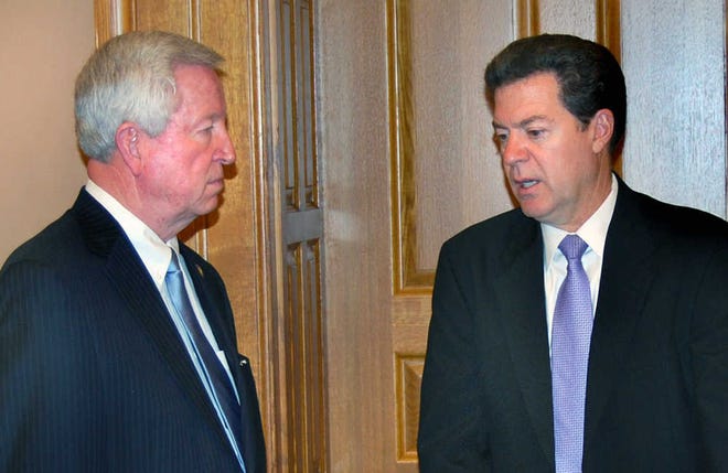 Senate President Steve Morris, R-Hugoton, and Gov. Sam Brownback confer at a meeting last summer about the federal govenment issuing unfunded mandates on the state.