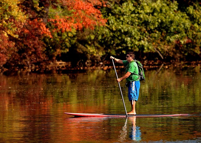 Tuesday's warm weather tempted Joe Randazzo of Framingham to take his stand-up paddle board to Lake Cochituate in Natick for a close-up view of the fall foliage.