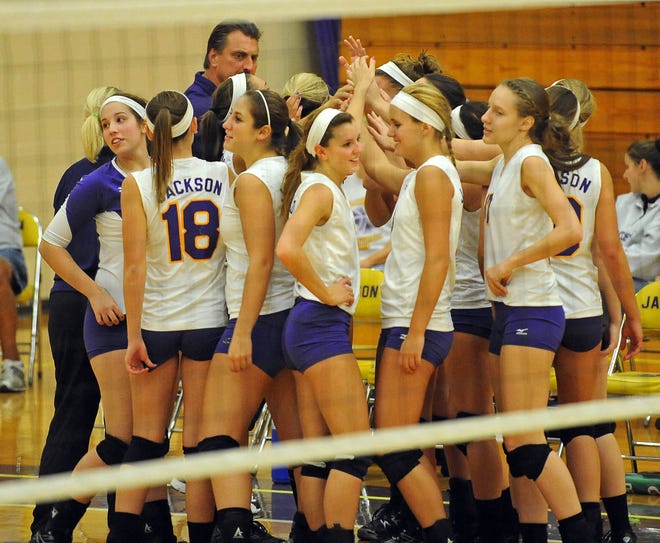 Coach Jeff Walck (back) brings the team together during a recent match for a cheer.