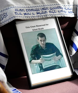 A chair draped with a prayer shawl and photograph honors captured Israeli Army Staff Sgt. Gilad Shalit. It has been empty at the front of the sanctuary at Temple Shir Tikva for three years. Shalit is expected to be released this week.