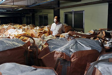 Toshiyuki Hattori, who runs a sewage plant in Tokyo, surrounded by sacks of radioactive sludge.