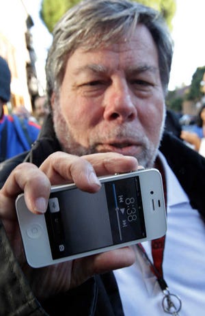 Apple co-founder Steve Wozniak holds up his new Apple iPhone 4S at the Apple store in Los Gatos, Calif., Friday, Oct. 14, 2011. Wozniak waited 20 hours in line to be the first Apple customer at the Los Gatos Apple store to buy the new iPhone. (AP Photo/Paul Sakuma)