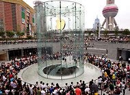 Crowds gathered in 2010 at the Apple store in Shanghai. It features a glass cylinder, as opposed to the Fifth Avenue store in Manhattan, with its glass cube.