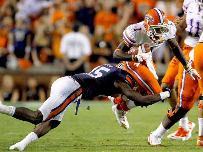 Florida Gators running back Chris Rainey (1) is tripped up by Auburn Tigers defensive back Neiko Thorpe (15) during the first half at Jordan-Hare Stadium in Auburn, Ala. on Saturday, Oct. 15, 2011.