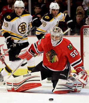 Bruins Tyler Seguin (left) and Nathan Horton (18) look on as Chicago goalie Corey Crawford blocks a shot during the first period of last night's game, won by Boston in a shootout.