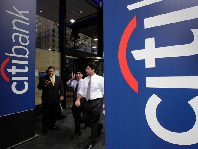In this Oct. 13, 2011 photo, people pass a Citibank office, in New York. Citigroup said Monday, Oct. 17, 2011, its earnings rose 74 percent in the third quarter, to $3.8 billion, after the bank recorded lower losses from loans. (AP Photo/Mark Lennihan)