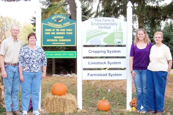 Left, Lee Farm owners Larry and Annette Lee with signs marking the Sesquicentennial status and recent MAEAP verification. At right are daughter Amanda (Lee) Berndt, his mother, Norma Lee.