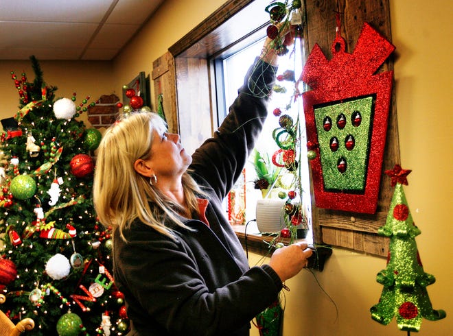 Lisa Chevalier of Andrews Landscapes Home & Garden Center located along Illinois 4 in Thayer hangs Christmas decorations Wednesday, Oct. 19, 2011, in preparation for a Christmas open house Nov. 6.