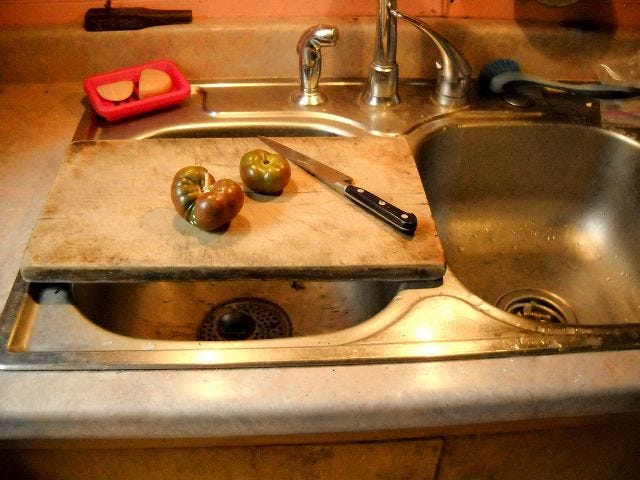 An old cutting board works fine and spans two sink basins.