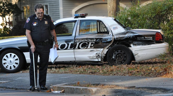 Officer Robert Tibor investigates a crash between a police cruiser and a van that occurred just before 4 p.m. yesterday at the intersection of Winter Street and Dunster Road in Framingham.