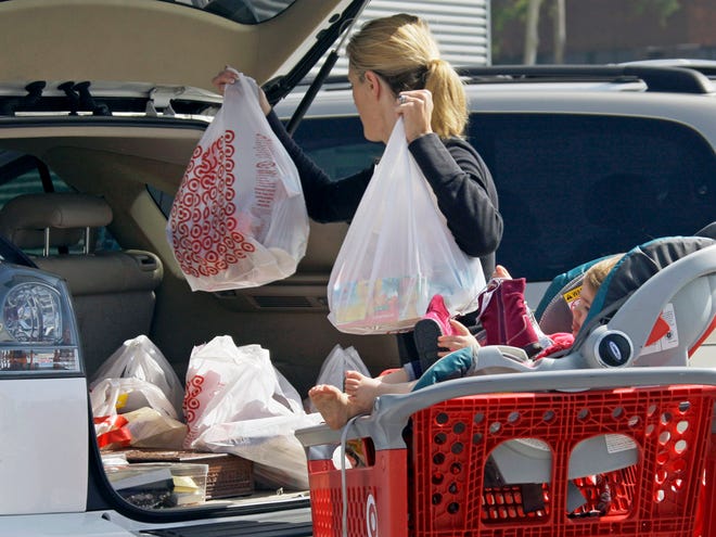 In this Sept. 29, 2011 file photo, a woman with a child loads purchases from a Target store into her car in Culver City, Calif. Consumer confidence declined in October in Florida and around the U.S. (AP)