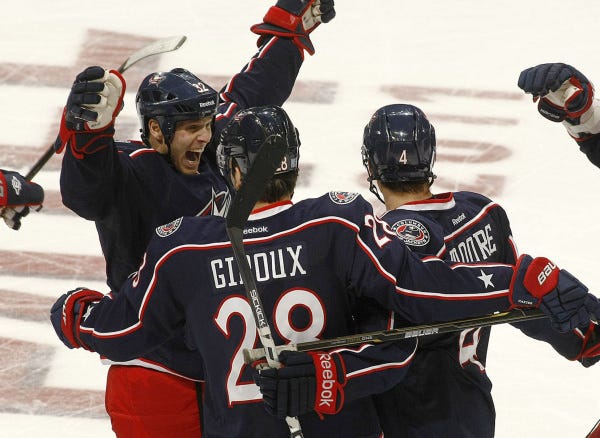 Teammates converge on Blue Jackets defenseman John Moore, right, who scored his first career goal in the second period.
