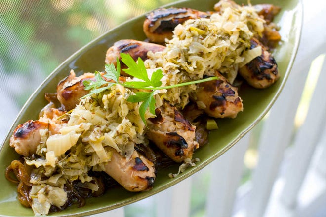 Hard cider-soaked apple-sage sausages with apple-fennel sauerkraut is a perfect recipe for a tailgate, a Halloween party, a football Sunday or an Oktoberfest.  (AP Photo/Matthew Mead)