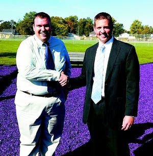 Bronson Rotary President Derek Shaw and City Manager Mark Heydlauff pose at Bronson’s Backyard. The Rotary helped fund the recent addition of purple rubber chips to the local playground.