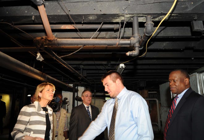 State Attorney General Martha Coakley visits the basement of a home on Lexington Street in Brockton where copper pipes were stolen. Patrick Flynn of Neighborhood Housing Services, and a construction specialist, gives the tour.