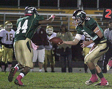Nashoba senior quarterback Trevor Wyand hands off to senior Carroll Bailey during the Chieftains' win over Doherty on Friday night. Both players are captains.