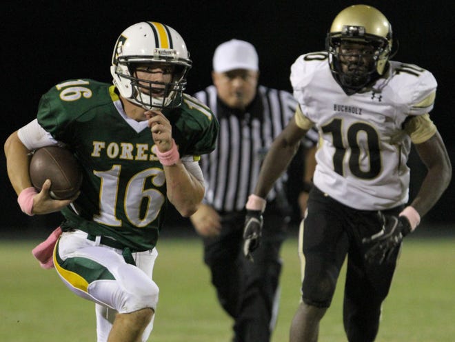 Forest's quarterback Jake Roddenberry (16) eludes Buchholz's Brandon Lindsey (10) for a large gain during Friday night's game at Forest High School in Ocala, Fla. on Oct. 28, 2011. (Star-Banner Photo/Bruce Ackerman) 2011.