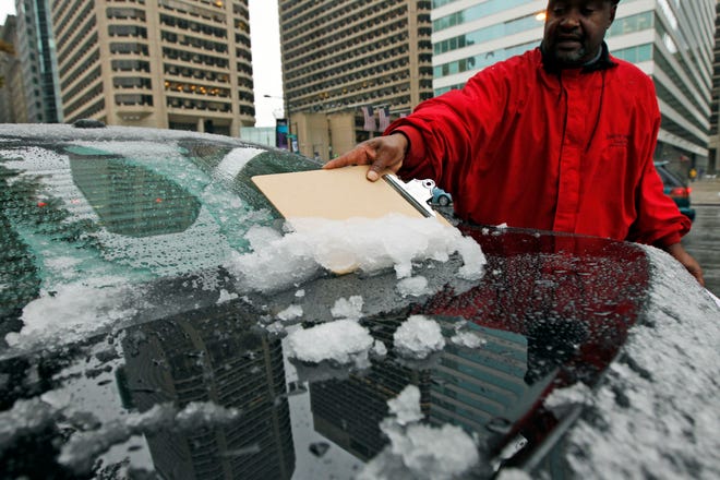 Les Lewis uses a clipboard to scrape the snow off of the back of his car window Saturday, Oct. 29, 2011 in Philadelphia, Pa. A classic nor'easter was chugging along up the East Coast and expected to dump anywhere from a dusting of snow to about 10 inches throughout the region starting Saturday, a decidedly unseasonal date for a type of storm more associated with midwinter. (AP Photo/Alex Brandon)