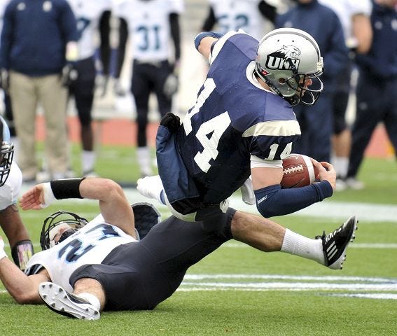 AP photo

UNH quarterback Kevin Decker, right, gets tripped up by Rhode Island linebacker Doug Johnson during the second quarter at Cowell Stadium on Saturday.