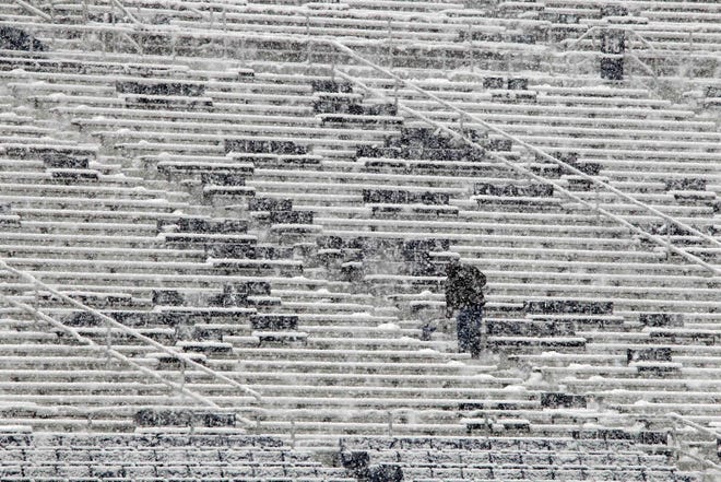 A worker shovels snow from the seats in preparation for an NCAA college football game between Penn State and Illinois at Beaver Stadium in State College, Pa., Saturday, Oct. 29, 2011. (AP Photo/Gene J. Puskar)