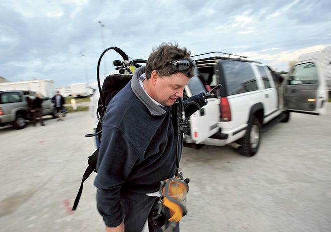 Rick Allen, carries his dive gear to the RV Shell Point, dock at Fort Macon Coast Guard station. [Staff photo by Cindy Burnham]